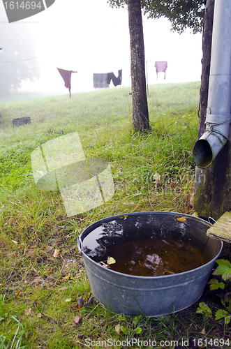 Image of Morning fog, laundry hang on rope bowl water 