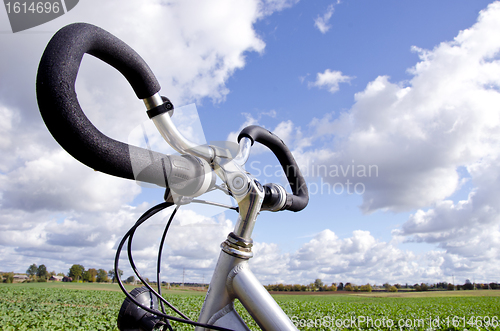 Image of Bicycle handlebar on cloudy sky. No fuel needed 