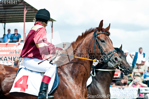 Image of jockey on racing horse before the start