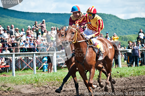 Image of Riders finish a race waving whips