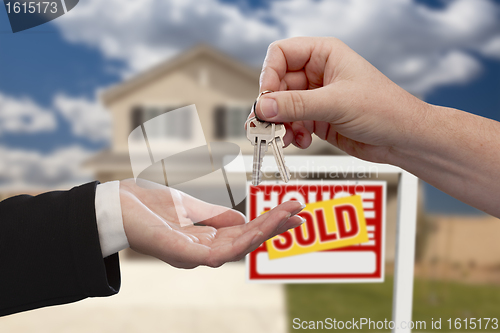 Image of Handing Over the House Keys in Front of Sold New Home