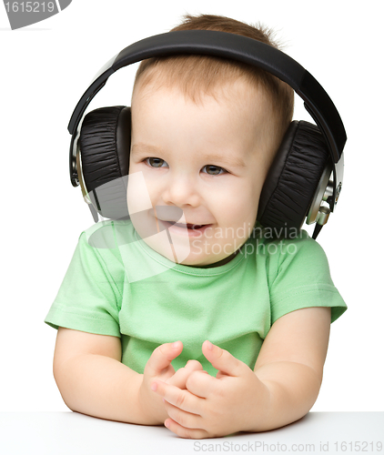 Image of Cute boy enjoying music using headphones