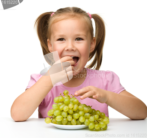 Image of Little girl is eating grapes