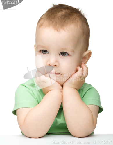 Image of Pensive little boy support his head with hand