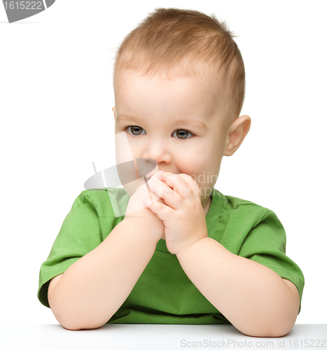 Image of Pensive little boy support his head with hand