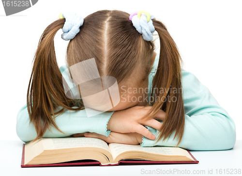 Image of Cute little girl is sleeping on a book