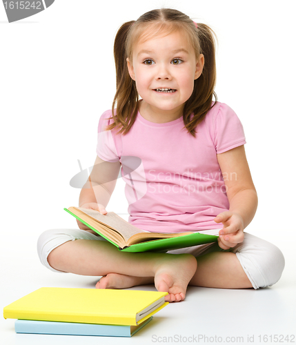 Image of Cute little girl reads a book