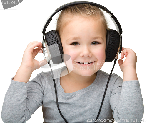 Image of Cute girl enjoying music using headphones