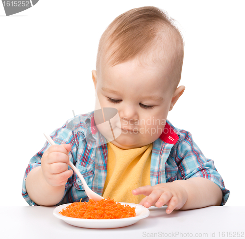 Image of Cute little boy is playing with carrot salad