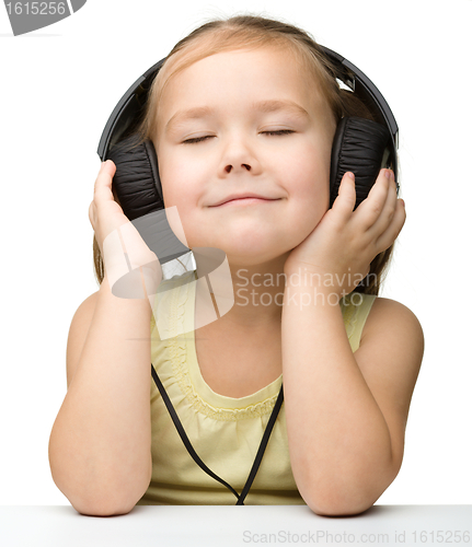 Image of Cute girl enjoying music using headphones