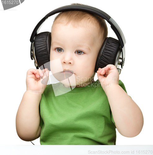 Image of Cute little boy enjoying music using headphones