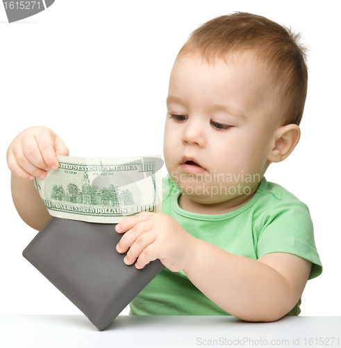 Image of Little boy is playing with dollars