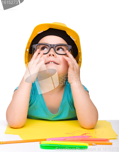 Image of Cute little girl is playing while wearing hard hat