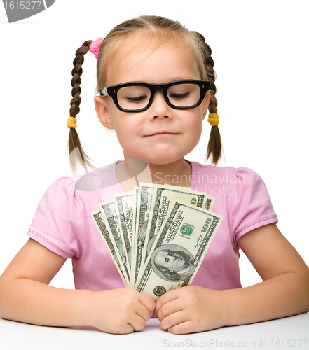 Image of Cute cheerful little girl with paper money