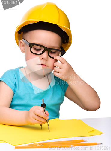 Image of Little girl play with divider wearing hard hat