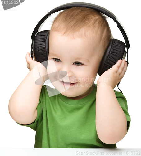 Image of Cute boy enjoying music using headphones