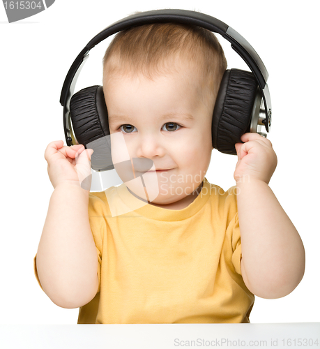 Image of Cute little boy enjoying music using headphones