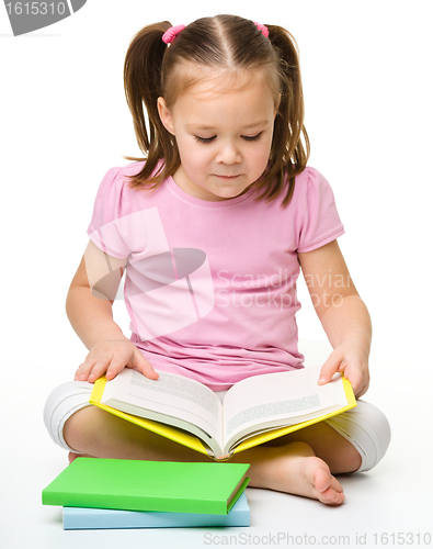 Image of Cute little girl reads a book
