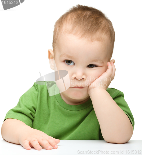 Image of Pensive little boy support his head with hand