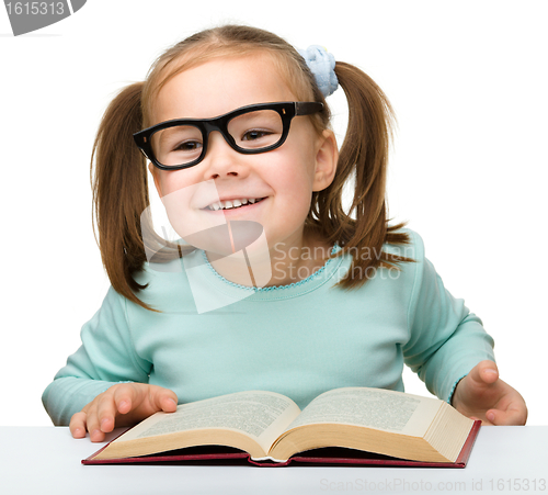 Image of Cute little girl reads a book