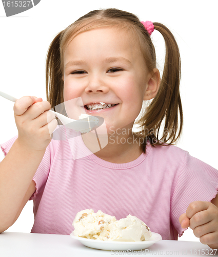 Image of Cute little girl is eating cottage cheese