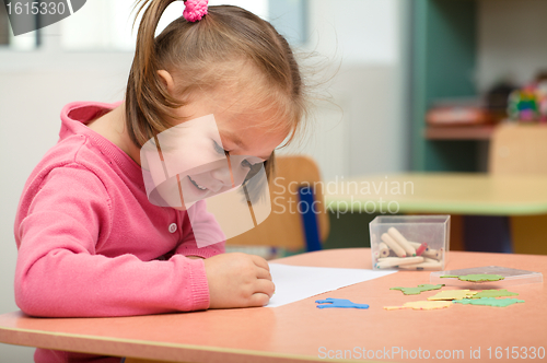 Image of Little girl is playing with plasticine