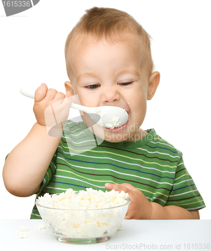 Image of Cute little boy is eating cottage cheese