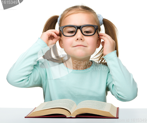 Image of Cute little girl reads a book