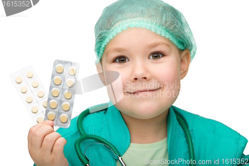 Image of Cute little girl is playing doctor with pills