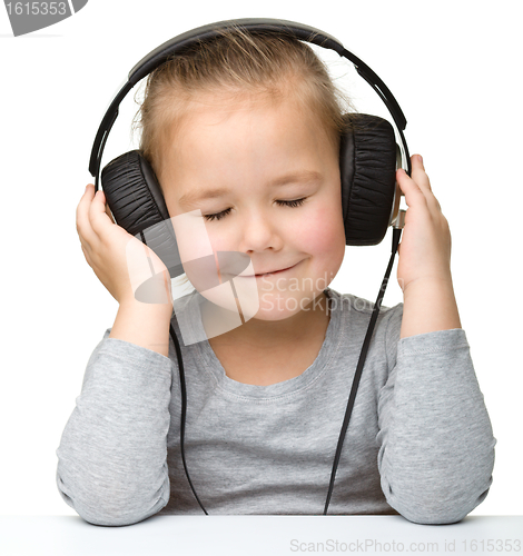 Image of Cute girl enjoying music using headphones