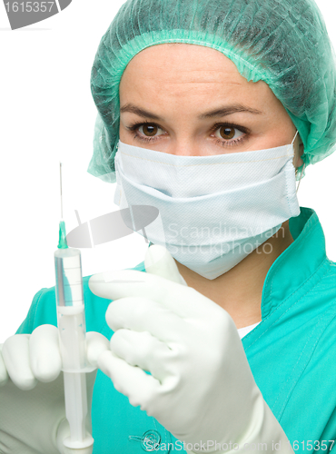 Image of Young nurse is preparing syringe for injection