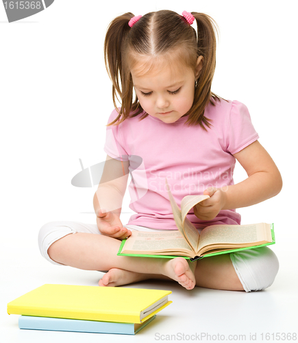 Image of Cute little girl reads a book