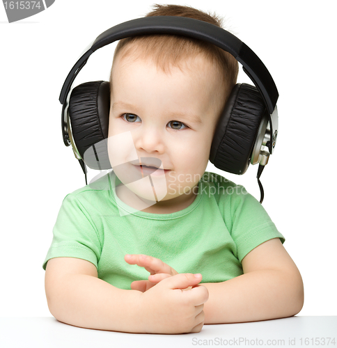 Image of Cute little boy enjoying music using headphones