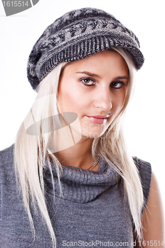 Image of Fashionable young woman in gray sweater and cap