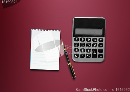Image of calculator, a pen and blank paper on the table 