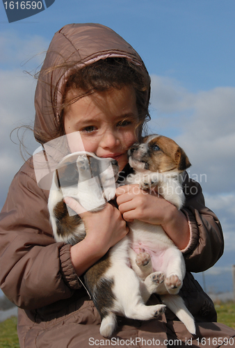 Image of sad little girl and puppies
