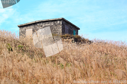 Image of old stone house with grass on the mountain 