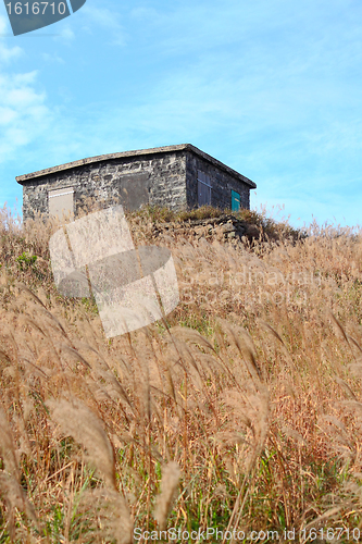 Image of old stone house with grass on the mountain 