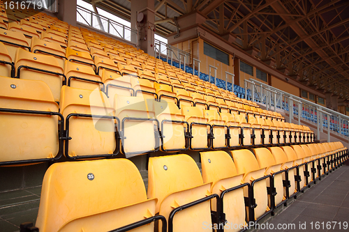 Image of Plenty of yellow plastic seats at stadium
