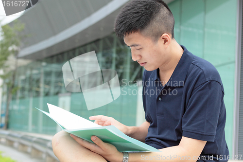 Image of casual asian businessman texting on his book. 
