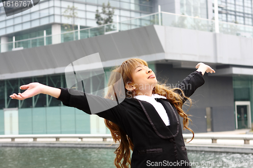 Image of Woman relaxing with arms open enjoying her freedom and office bu