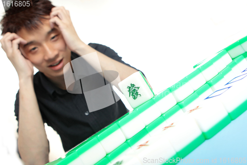 Image of Chinese man play Mahjong, traditional China gamble. 