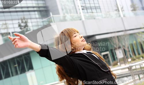 Image of Woman relaxing with arms open enjoying her freedom and office bu