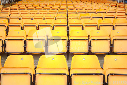 Image of Plenty of yellow plastic seats at stadium