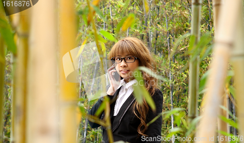 Image of beautiful asian woman using smart phone in the park