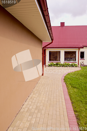 Image of House with large windows and red tiled roof.