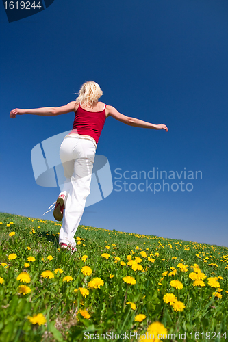 Image of young woman in red outfit having fun on meadow