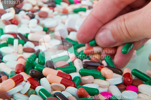 Image of hand grabbing pills