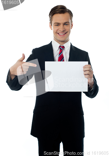 Image of Young salesman pointing towards blank billboard