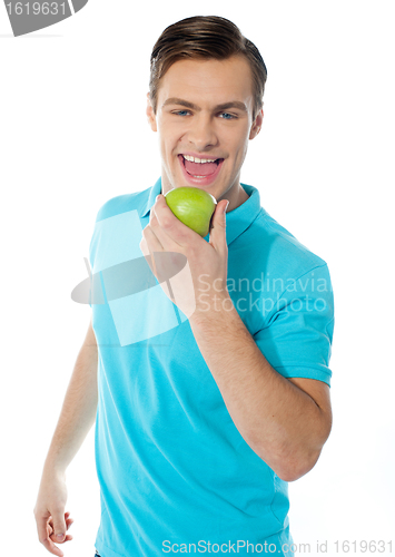 Image of Handsome young caucasian biting an apple